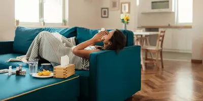 Eine Frau mit Husten versucht einen Tee zu trinken