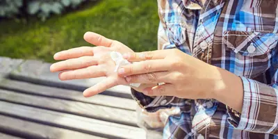 Eine Kind reinigt seine Hände mit einem Taschentuch