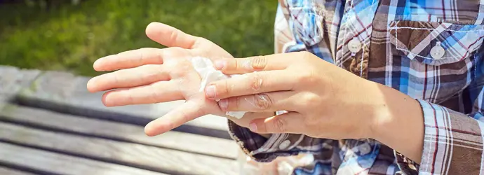 Eine Kind reinigt seine Hände mit einem Taschentuch