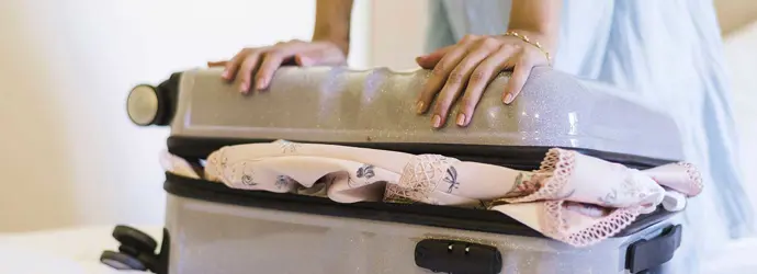 Eine Frau versucht eine Kliniktasche zu schließen