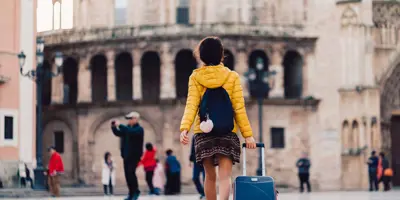 Ein Student läuft in die Richtung eines alten Gebäudes in Valencia