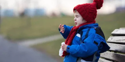 Ein Kind niest auf einer Parkbank im Winter