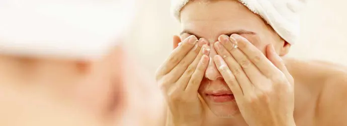 Frau wäscht ihre Augen nach einer Dusche