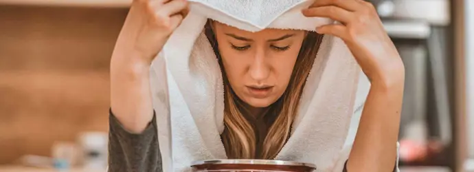 Vrouw voert een inhalatiebehandeling uit als remedie voor bijholteontsteking