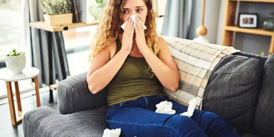 Vrouw met verkoudheids- of hooikoortssymptomen snuit haar neus