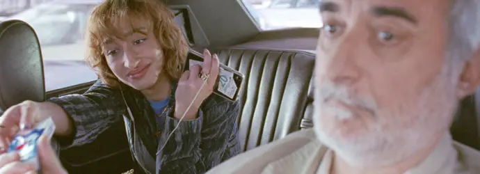 Un tassista passa un pacchetto di fazzoletti Tempo a una donna seduta sul sedile posteriore