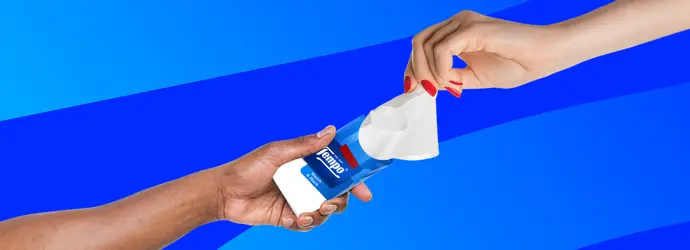 Due mani si scambiano un pacchetto di fazzoletti Tempo davanti a uno sfondo a strisce blu.