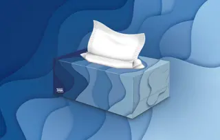 Eine Tempo-Taschentuchbox vor blauem Hintergrund.