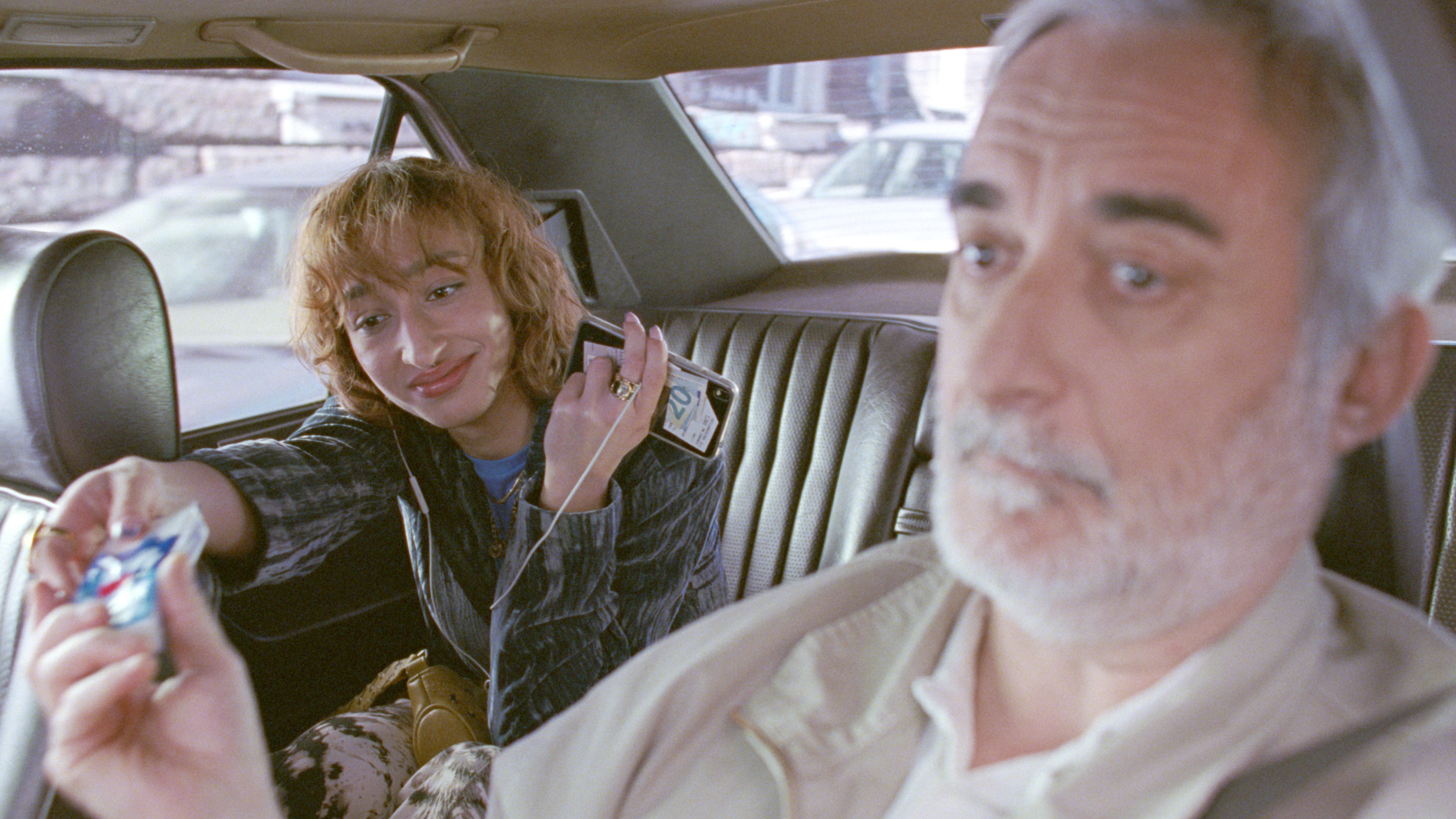 Un tassista passa un pacchetto di fazzoletti Tempo a una donna seduta sul sedile posteriore