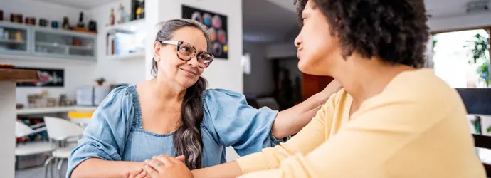 Una persona con i capelli ricci che sorride durante una conversazione.