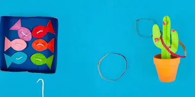 Una scatola di cartone decorato con i pesci e un cactus di cartone per giocare come giochi per bambini da esterno