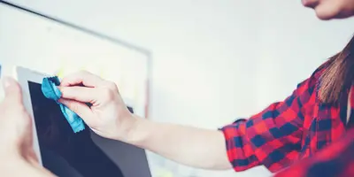 Una donna pulisce lo schermo di un dispositivo mobile o di un computer