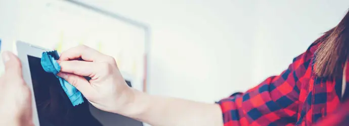 Una donna pulisce lo schermo di un dispositivo mobile o di un computer