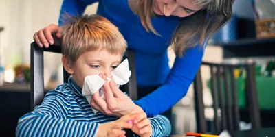 Una madre aiuta suo figlio a soffiarsi il naso
