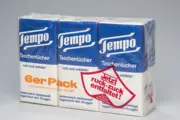 Frühe Tempo Mehrfachpackung mit drei Taschentuch Päckchen und rotem Etikett für leichtes Öffnen.
