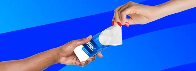 Due mani si scambiano un pacchetto di fazzoletti Tempo su uno sfondo a strisce blu