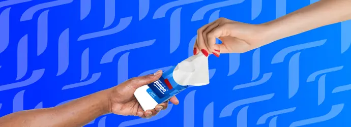 Twee handen wisselen een Tempo-zakdoekjespak uit tegen een blauwe achtergrond met Tempo T-motief