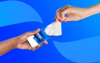 Zwei Hände tauschen eine Tempo-Taschentuchpackung vor einem blauen Hintergrund mit abstrakten geschwungenen Formen aus