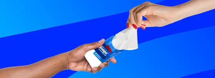 Due mani che si scambiano un pacchetto di fazzoletti Tempo su uno sfondo blu con motivo Tempo T