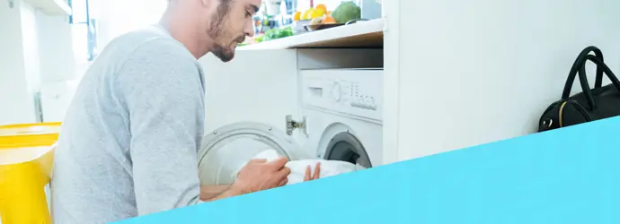 Bild eines Mannes, der eine Waschmaschine belädt, überlagert von einem diagonalen blauen Tempo-Muster in der rechten Ecke.