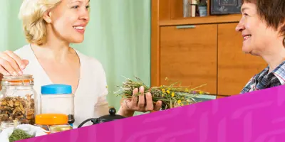 Bild von zwei Frauen, die sich an einem Tisch unterhalten, überlagert von einem diagonalen lila Tempo-Muster in der rechten unteren Ecke.