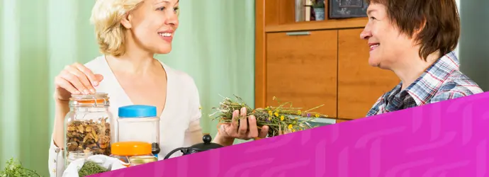 Bild von zwei Frauen, die sich an einem Tisch unterhalten, überlagert von einem diagonalen lila Tempo-Muster in der rechten unteren Ecke.