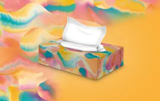 Eine Tempo-Taschentuchbox vor orangem Hintergrund.