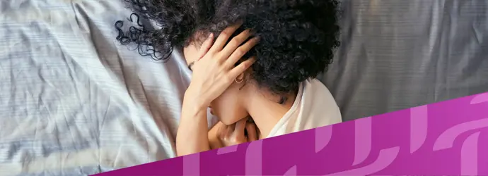 Bild einer im Bett liegenden Frau, die sich den Kopf hält, überlagert von einem diagonalen lila Tempo-Muster in der rechten Ecke.