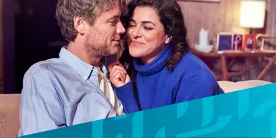 Bild eines Paares, das auf einer Couch sitzt, überlagert von einem diagonalen blauen Tempo-Muster in der rechten unteren Ecke.