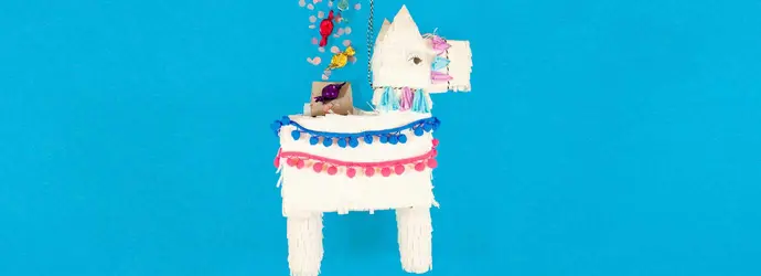 Weiße Lama Pinata bedeckt mit Fransen aus Papiertaschentüchern aus dem Süßigkeiten quellen
