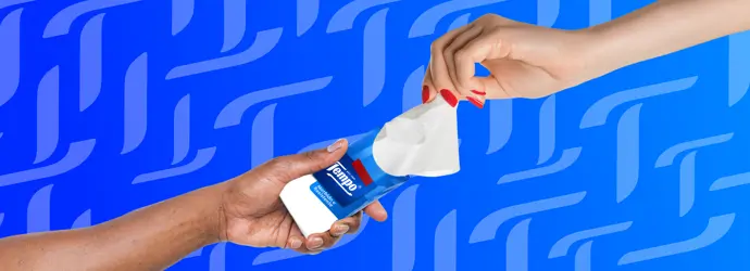 Due mani che si scambiano un pacchetto di fazzoletti Tempo su uno sfondo blu con motivo Tempo T