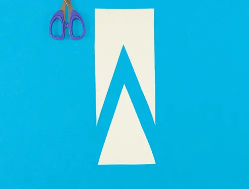 Due ritagli di carta tagliati in due forme che combaciano sono su sfondo celeste con accanto delle forbici.